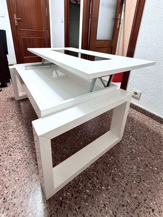 Mesa elevable blanca con almacenaje.