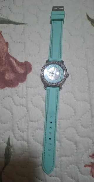 Reloj plateado con correa turquesa