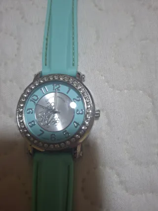 Reloj plateado con correa turquesa