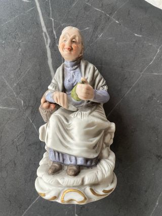 Statuetta anziana con cesto e frutta