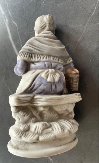 Statuetta anziana con cesto e frutta