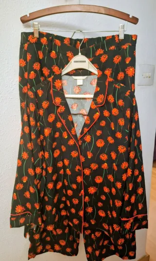 Traje de pantalón negro y rojo de flores.