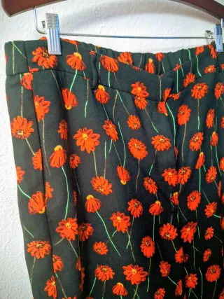 Traje de pantalón negro y rojo de flores.