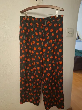 Traje de pantalón negro y rojo de flores.