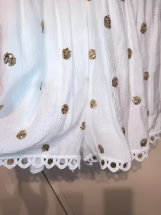 Mono corto blanco con lentejuelas doradas