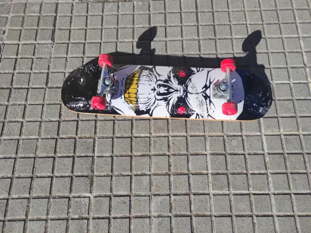 Monopatín negro con ruedas rojas, muy poco uso