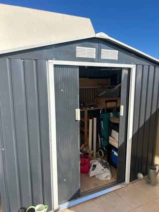 Caseta exterior metálica negra con puerta