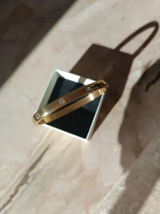 Pulsera dorada con detalles brillantes,en acero