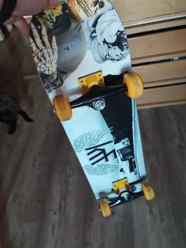 Monopatín negro con logo amarillo