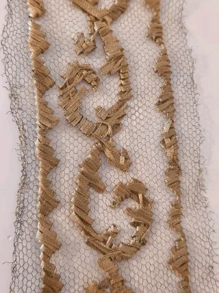 Encaje metálico dorado.