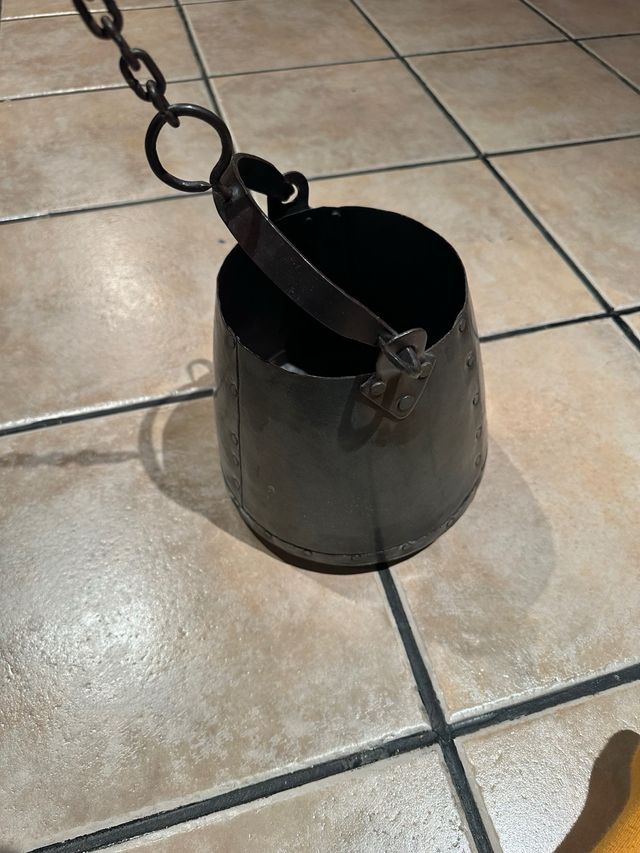 Cubo rústico de metal con cadena