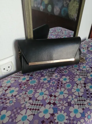 Bolso de mano negro con cadena dorada