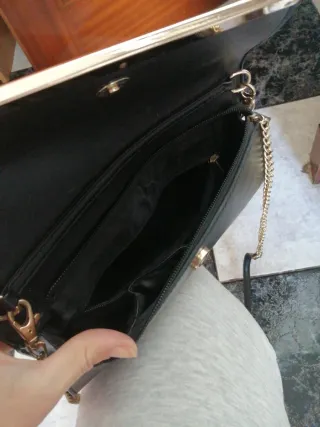 Bolso de mano negro con cadena dorada
