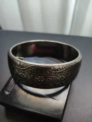 Brazalete plateado con detalles relieve florales.