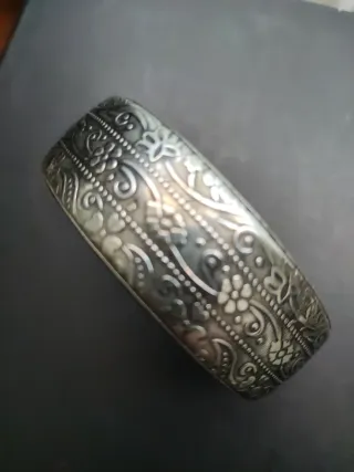 Brazalete plateado con detalles relieve florales.