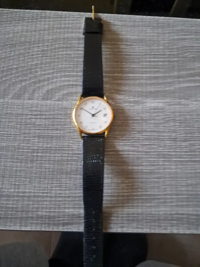 Reloj de pulsera dorado con correa negra
