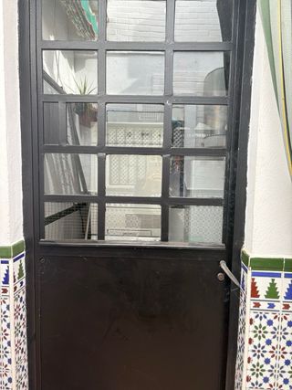 Puerta de hierro con cristal y palilleros