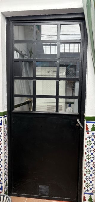 Puerta de hierro con cristal y palilleros