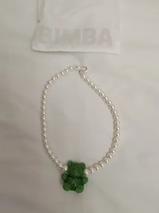 Collar de perlas con oso verde.