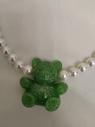 Collar de perlas con oso verde.
