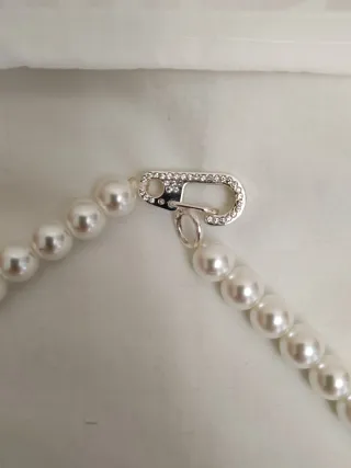 Collar de perlas con oso verde.