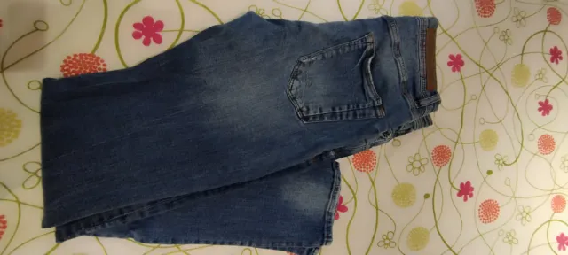 Pantalón vaquero azul oscuro roto.