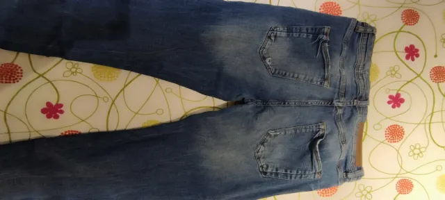 Pantalón vaquero azul oscuro roto.