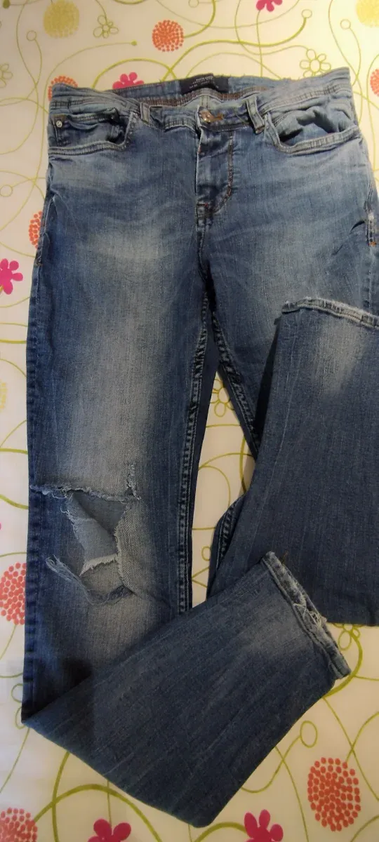 Pantalón vaquero azul oscuro roto.