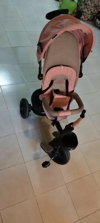 Triciclo infantil con mandos para conducción.