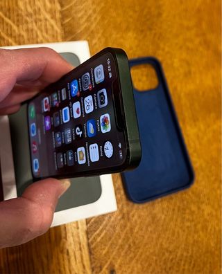 iPhone 13 mini verde con custodia blu marino