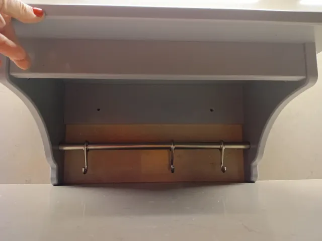 Estantería gris Ikea con barra y ganchos.