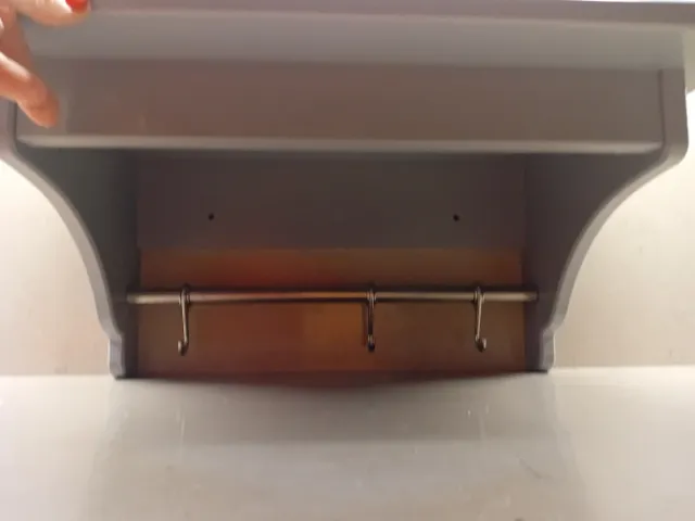 Estantería gris Ikea con barra y ganchos.