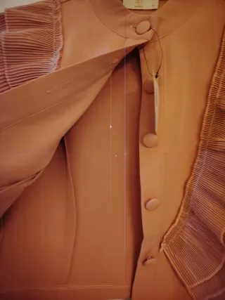 Casaco rosa com botões e folhos.