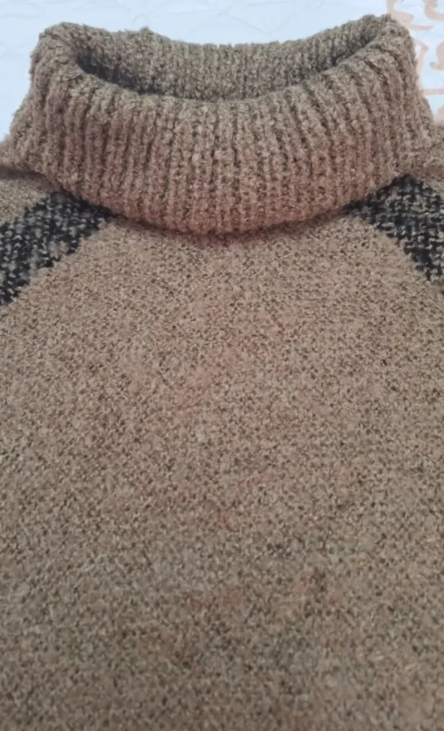 Poncho de punto con cuello alto y flecos