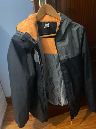 Chaqueta Quechua impermeable con forro naranja.