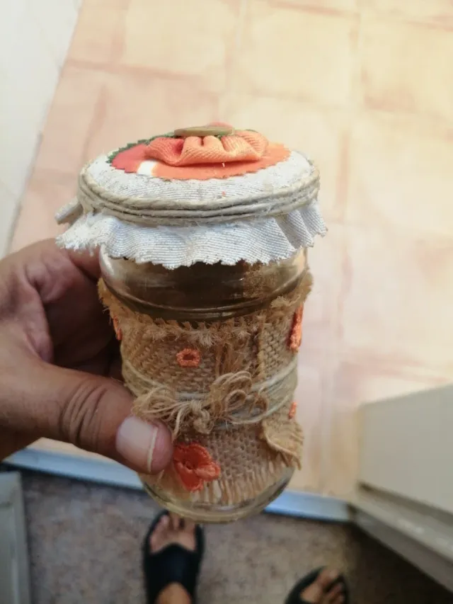 Tarro de cristal decorado con rafia y flores