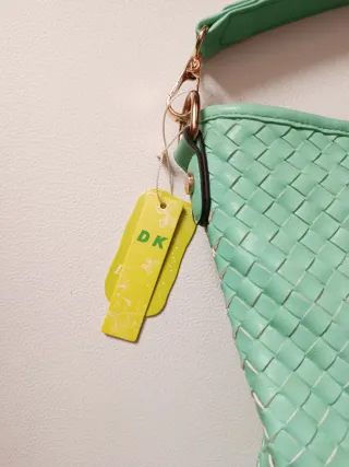 Bolso verde tejido con detalles dorados