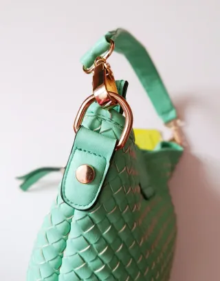 Bolso verde tejido con detalles dorados