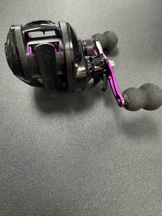 Carrete de pesca negro y morado