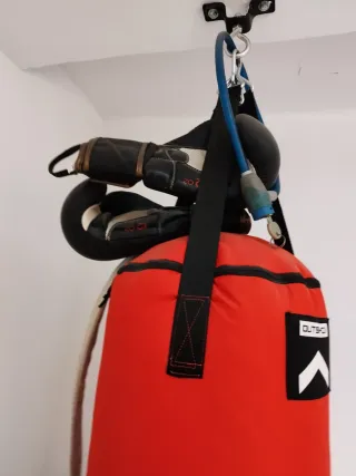 Saco de boxeo rojo con guantes y cinturón