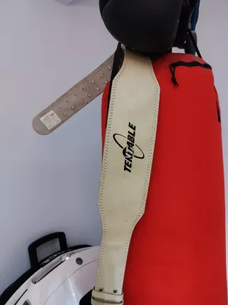 Saco de boxeo rojo con guantes y cinturón