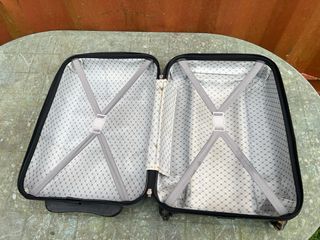 Maleta de viaje plateada con algún roto