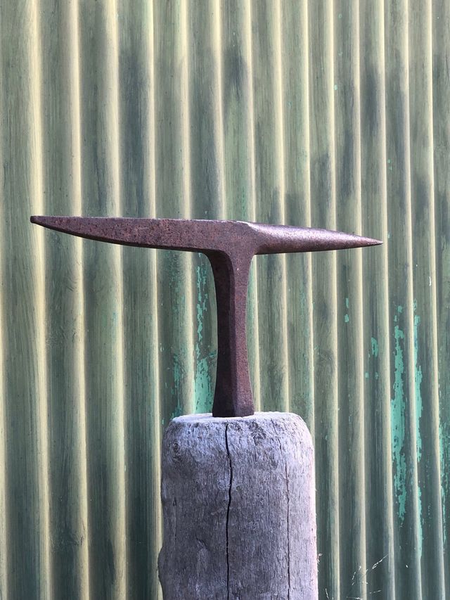 Yunque antiguo sobre base de madera