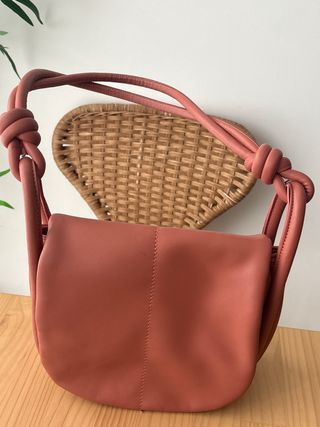 Bolso de mano rosa con nudo