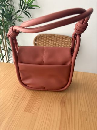 Bolso de mano rosa con nudo