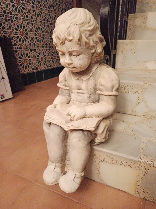 Escultura niña leyendo libro