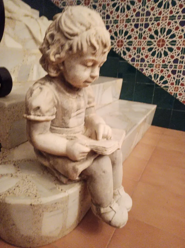 Escultura niña leyendo libro
