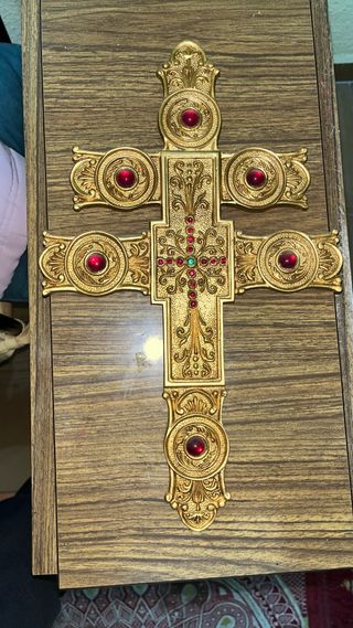 Cruz decorativa dorada con piedras rojas