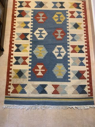 Alfombra de tela beige, amarillo y azul.