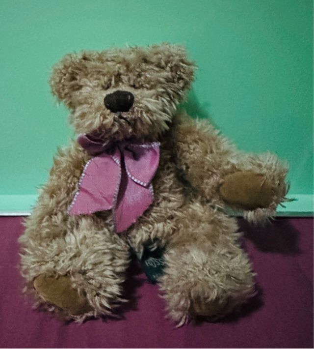 Osito de peluche marrón con lazo rosa